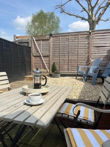 a picnic table in a backyard with chairs and a fence at Stylish Caversham Town-House Free Parking & Garden in Caversham