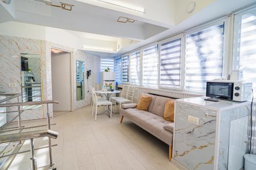 Iancu Jianu Premium Stay Apartment في بوخارست: غرفة معيشة بها أريكة وطاولة