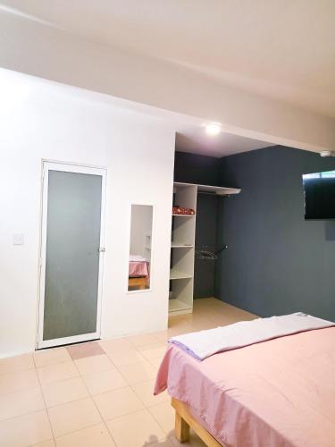a bedroom with a bed and a sliding glass door at Habitación estándar tancitaro in Oaxaca City