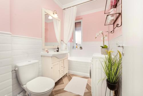 a bathroom with a toilet and a sink and a tub at Charming French Getaway Spacious Apartment with Garden and Parking in Dumbrăviţa