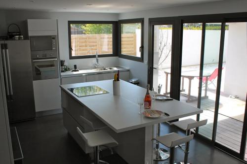 a kitchen with a counter and a table and chairs at Mimosette Villa pool & jacuzzi 4 bedrooms in Le Pouliguen