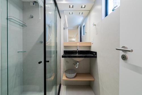 a bathroom with a glass shower and a sink at Aurea Cabo Branco Beach in João Pessoa