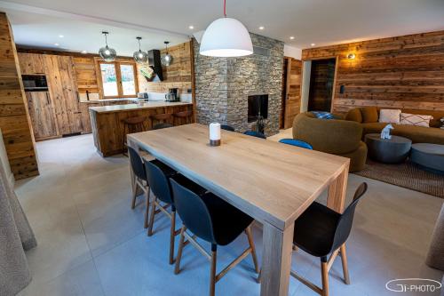 een keuken en woonkamer met een houten tafel en stoelen bij Chalet Azureva Le Bettaix in Levassaix