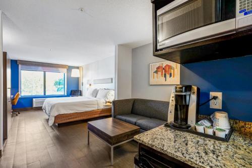 a hotel room with a bed and a living room at Holiday Inn Express & Suites Jacksonville - Atlantic Beach by IHG in Jacksonville