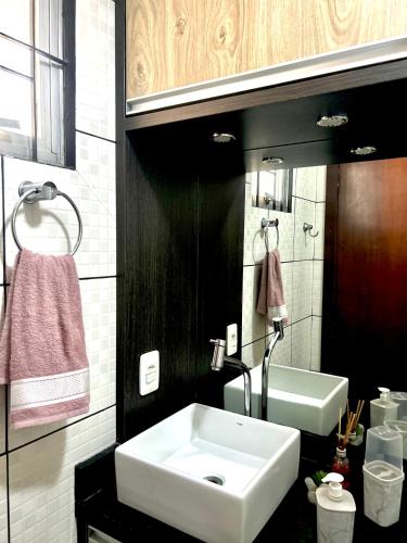 a bathroom with a white sink and a mirror at Apartamento completo no centro da cidade in Passo Fundo