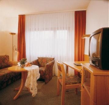 sala de estar con sofá, mesa y TV en Oberdeisenhof Land- und Wanderhotel Garni, en Baiersbronn