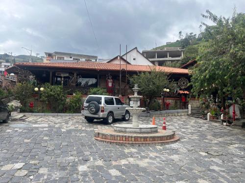 un SUV parcheggiato davanti a un edificio con una fontana di La Rustica Hotel a Guaranda