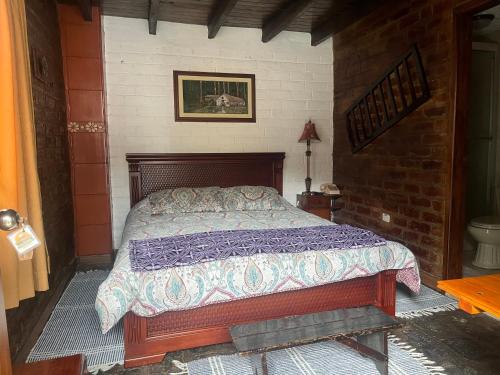 una camera da letto con un letto in un muro di mattoni di La Rustica Hotel a Guaranda