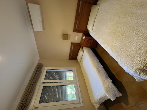 een kleine kamer met een bed en een raam bij Met y playa in Casas Devesa