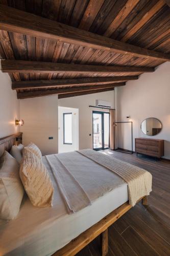 a large bed in a room with wooden ceilings at Cevizdibi Loft Villa in Kartepe