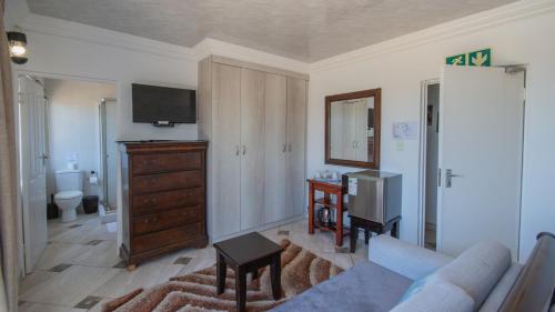 マーゲートにあるFalling Waters Guest Houseのソファとテレビのあるリビングルーム