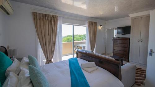 マーゲートにあるFalling Waters Guest Houseの大きなベッドとバルコニーのある寝室