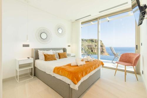ein Schlafzimmer mit Bett und Meerblick in der Unterkunft Villa CLIFF HEAVEN HOUSE in Calheta