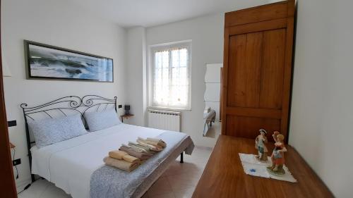 Lunigiana - Casa Anita Con Giardino في كاستيلنوفو ماغرا: غرفة نوم بسرير وطاولة عليها مناشف