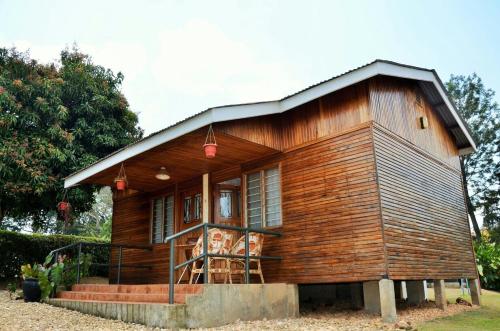 a small wooden house with a porch at Bwigamiro Country Home Fort Portal in Fort Portal