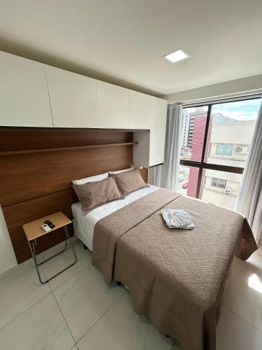 um quarto com uma cama grande e uma janela grande em Melhores Flats - Tranquilo, pertinho do mar em João Pessoa