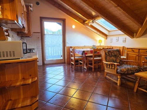 ジアーノ・ディ・フィエンメにあるAttico Lagorai - Alpine Stay Apartmentsのテーブルと椅子のあるキッチンとダイニングルーム