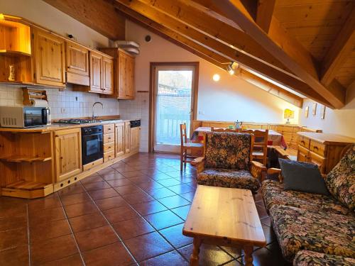 ジアーノ・ディ・フィエンメにあるAttico Lagorai - Alpine Stay Apartmentsのソファとテーブルのあるキッチンとリビングルーム
