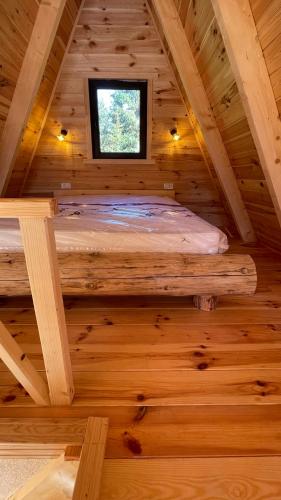 a bedroom in a log cabin with a window at Vila Caričić Žabljak in Žabljak