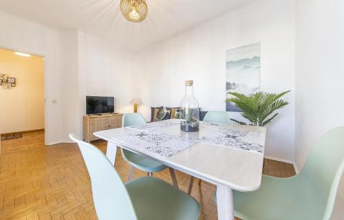 a dining room with a white table and chairs at Abrotea Apartments in Lagos
