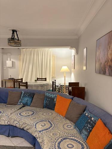 Una sala de estar con un sofá azul con almohadas de colores. en Villa Sela Gem, en El Cairo