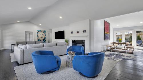 a living room with a couch and blue chairs at Modern Villa Retreat in Historic College Park in Atlanta