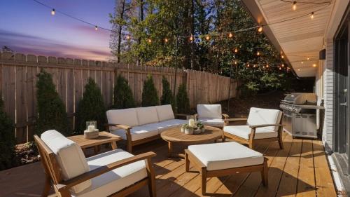 a patio with a couch and chairs and a grill at Modern Villa Retreat in Historic College Park in Atlanta