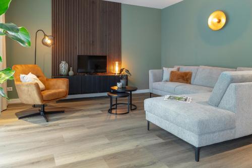 a living room with a couch and a chair at Luxe appartement 4 personen #2