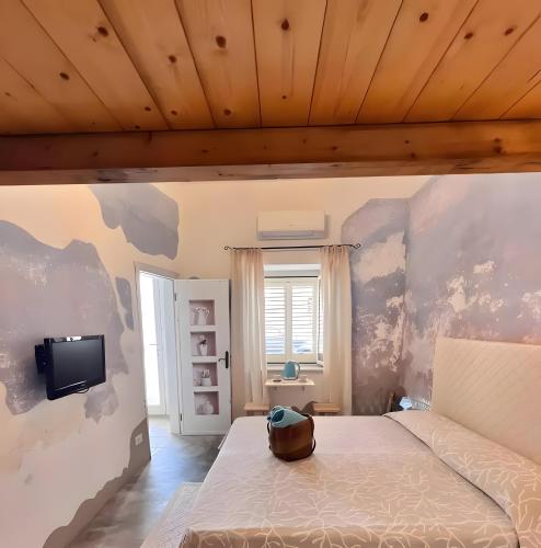 Camera di Zio Peppe- Vintage Room في سانتا تيريزا غالّورا: غرفة نوم بها سرير وتلفزيون على الحائط