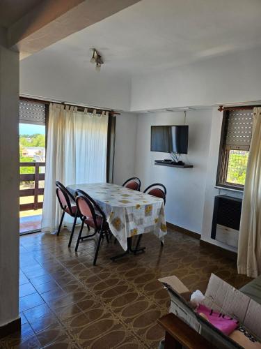 una sala da pranzo con tavolo e sedie di Departamento Villa Gesell 3 cuadras de la playa a Villa Gesell