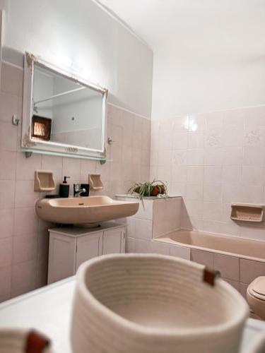 ein Badezimmer mit Waschbecken, Spiegel und Badewanne in der Unterkunft Ta Sokakia in Karpenisi