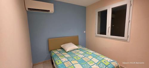 Ένα ή περισσότερα κρεβάτια σε δωμάτιο στο EMBRUN Appartement climatisé cosy 2 chambres au 1er étage pour 4 personnes au Barcarès