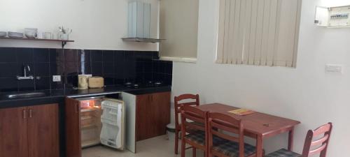 GTA&H BY Shan في كاندوليم: مطبخ مع طاولة وطاولة وكراسي