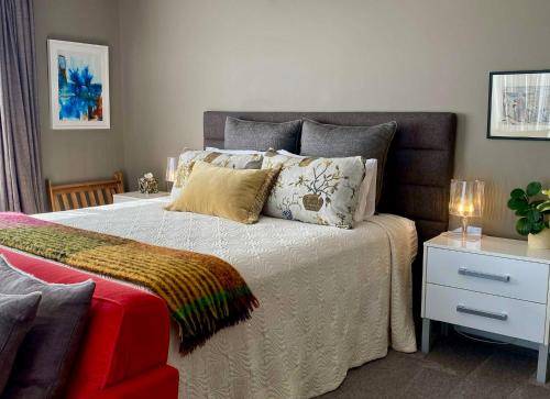 a bedroom with a bed with pillows and a night stand at Escape in New Plymouth
