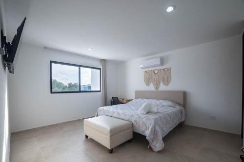 una camera da letto bianca con un letto e una finestra di Casa Cholul a Cholul