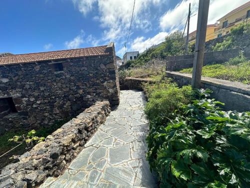 a stone walkway next to a stone wall at Casa Rural Higuera Morales in Mocanal