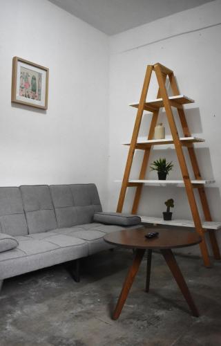 a living room with a couch and a wooden shelf at Casita en el centro de Oaxaca cerca de Santo Domingo in Oaxaca City
