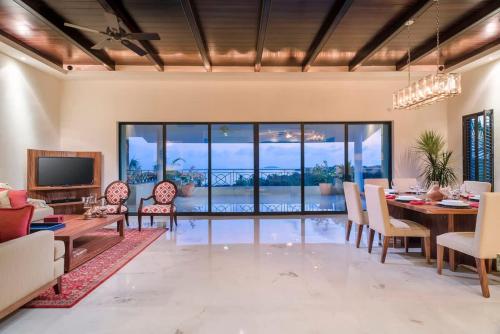 ein Esszimmer mit Tisch und Stühlen und einem Fernseher in der Unterkunft Luxury Oceanview Penthouse in HDM in Punta Mita