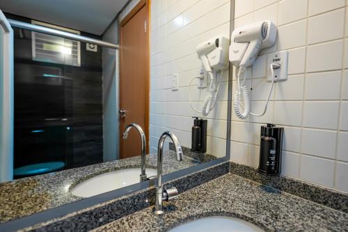a bathroom with a sink and two hair dryers at ibis Styles Belem Batista Campos in Belém