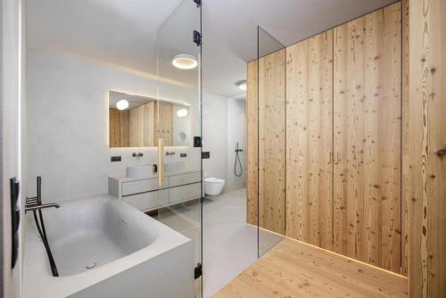 un baño con bañera y ducha de cristal en Vronis Lodge, en Hart im Zillertal