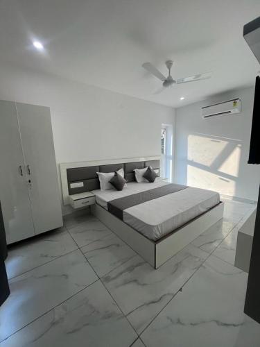 a white bedroom with a bed and a ceiling at Sky s whiye house in Ludhiana