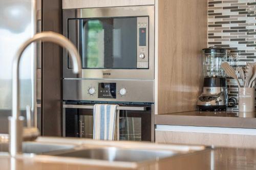 棕榈滩Eagle Beach - Luxury Beachscape 2BR condo - LV302的厨房配有带微波炉的不锈钢烤箱