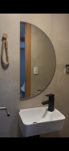 a bathroom with a white sink and a mirror at Charmoso dúplex canto do jandaia in Mata de Sao Joao