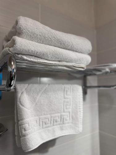 a bunch of towels on a towel rack in a bathroom at DREAM Hotel Kyiv in Kyiv