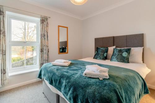 una camera da letto con un letto grande con asciugamani sopra di 1 Pump Cottages a Theberton