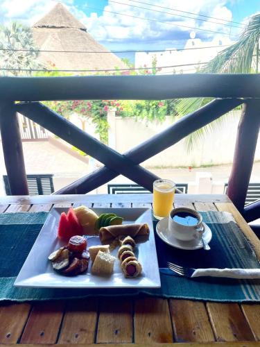 une assiette de nourriture et une tasse de café sur une table dans l'établissement Jabulani House Rooms, à Kendwa
