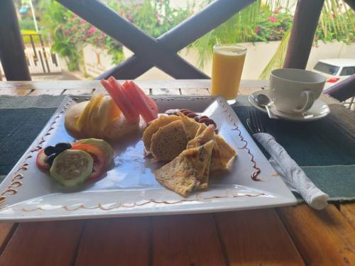 une assiette de nourriture sur une table avec une boisson dans l'établissement Jabulani House Rooms, à Kendwa