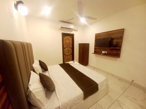 ein Schlafzimmer mit Bett und Flachbildfernseher in der Unterkunft Hotel A regency in Ludhiana