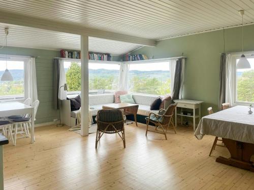 a living room with a couch and a table and chairs at Family Cabin With Fjord Views In Drøbak Heights in Drøbak
