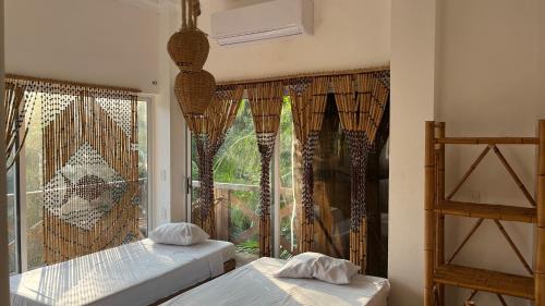 two beds in a room with a window at Hostal Axlan in Puerto Escondido